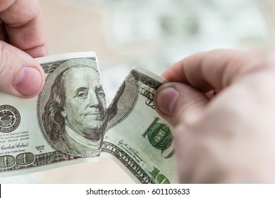 Torn dollar. Two hands tearing dollar bill