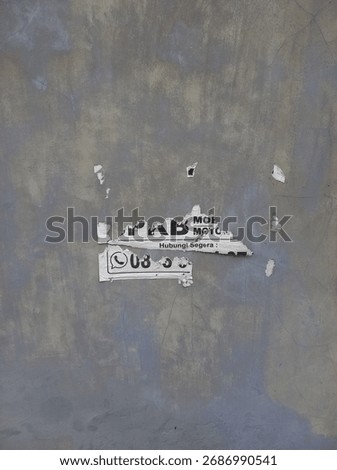 A torn flyer is attached to the wall.