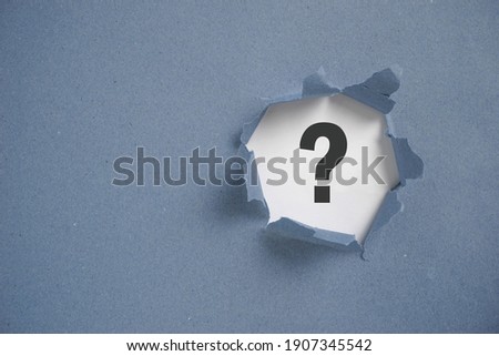 Torn grey paper with question mark. Question mark concept.                               