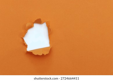 Torn hole orange paper pattern background