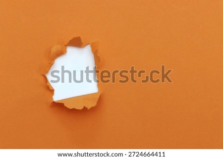 Torn hole orange paper pattern background