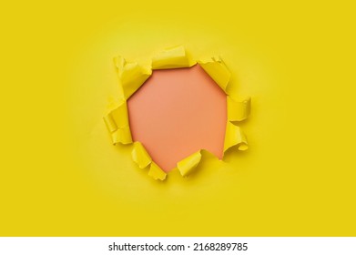Torn hole in yellow paper with pink empty background. Copy space, mockup. Place for text or logo. - Shutterstock ID 2168289785