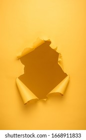 torn hole in yellow paper texture with copy space