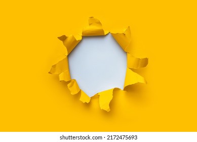 Torn hole in yellow paper with white empty background. Copy space, mockup. Place for text or logo. - Shutterstock ID 2172475693