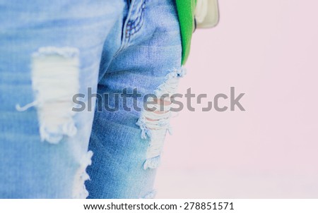 Torn jeans on a pink background so close back focus