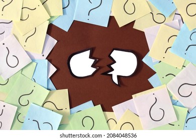 A torn mark for writing thoughts surrounded by question marks painted on pieces of paper.