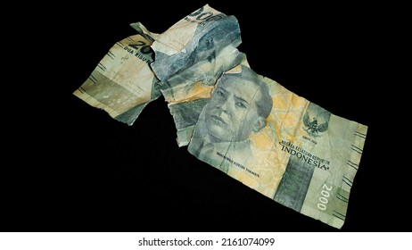Torn money, old and torn banknote isolated on black background. World finance concept.