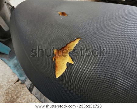 Torn motorbike seats, old black leather seats with holes damaged leather. 