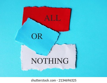 Torn Note Paper On Blue Background With Text Written ALL OR NOTHING Means Doing Something Either Completely Or Not At All - Not Allowing For Qualification Or Compromise