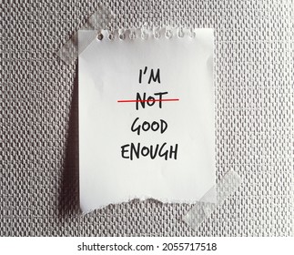 Torn note paper written I AM NOT GOOD ENOUGH , change to I AM GOOD ENOUGH , concept pf self improvement by boosting self esteem and change negative inner perception to be positive one