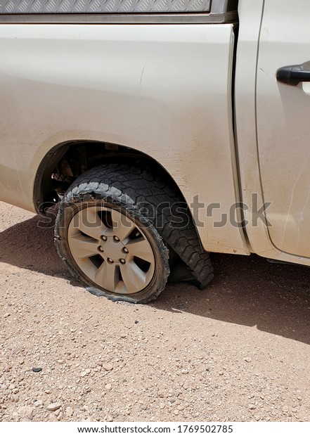 Torn off-road tire tire detaches from a drive-off\
disc on a dirt road
