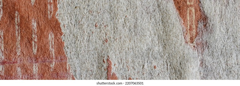 Torn Old Faded Paper Wallpaper With A Retro Pattern. Tattered Scraps Of Paper On The Wall. Wide Panoramic Texture For Background And Design.