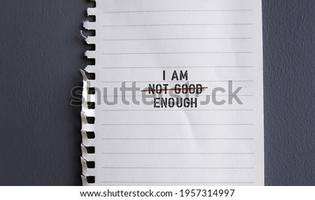 torn paper note with text I AM NOT GOOD ENOUGH with red crossing on NOT GOOD , concept of self worth , stop striving for approval, more valid , more loved or validation , you are good enough