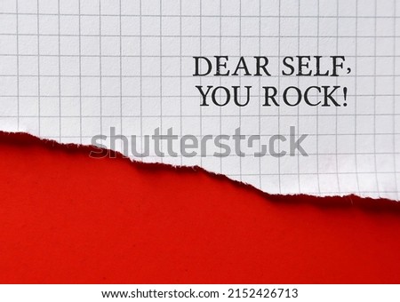 Torn paper on copy space orange background with text DEAR SELF YOU ROCK, concept of positive self talk tor daily affirmation to raise self esteem and self acceptance