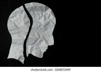Torn paper in the shape of a person's head on a black background. mental health issues, Anxiety, depression, broken mood and mindfulness awareness concept.