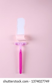 Torn Paper And Sharp Pink Razor On The Pink Backround.Vertical Shot.Concept Of 
Safe Shaving