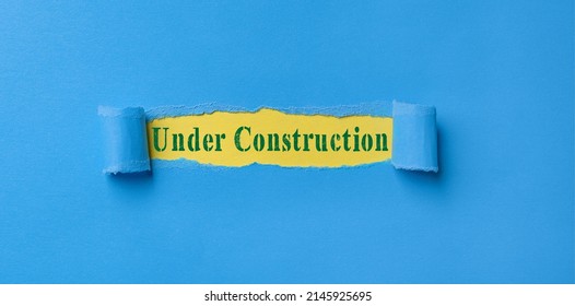 Torn paper strip on bleu background with text under construction, under construction