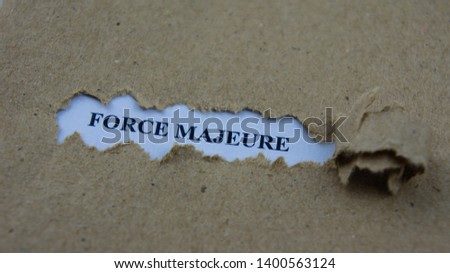 Torn paper with text force majeure. Legal term mean unforeseeable circumstances that prevent someone from fulfilling a contract.