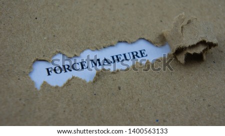 Torn paper with text force majeure. Legal term mean unforeseeable circumstances that prevent someone from fulfilling a contract.