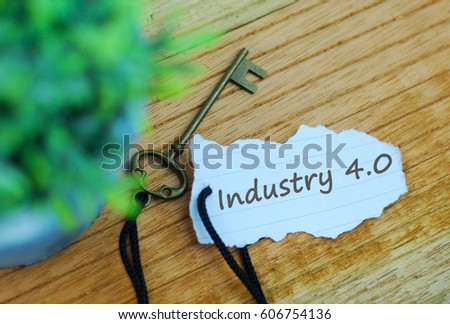 Torn paper with text industry 4.0 and key on wooden background