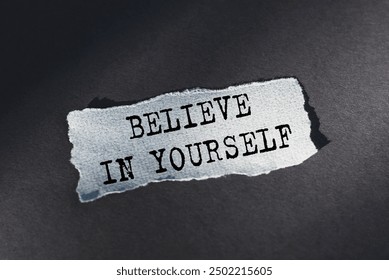 A torn piece of paper with the phrase believe in yourself written on it.
