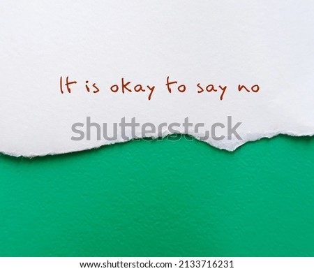 Torn ripped paper on green rough texture background IT IS OKAY TO SAY NO, means no one can make everyone happy, Stop people pleasing, be true and comfortable to say no when you want to