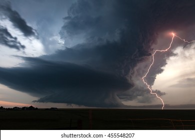 Tornado alley extreme rotating supercell thunderstorm with vivid lightning strike at dusk.
