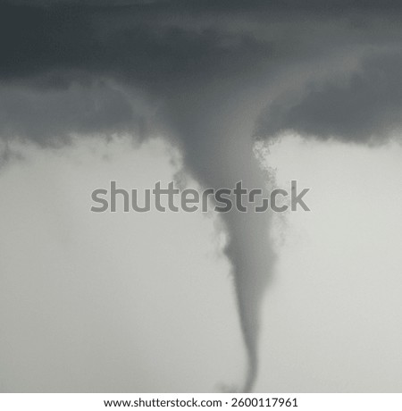 A tornado in the dark sky during a cloudy day
