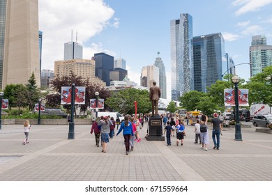 Toronto, Canada - 26 June 2017: People Walking On Bremner Blvd In Downtown Toronto, With Toronto Cityscape In The Background