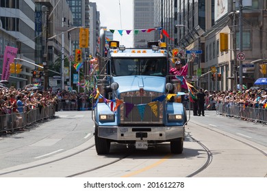 TORONTO, CANADA - 29TH JUNE 2014: People participating in the World Pride Parade in Toronto. Spectators can be seen beside the path.