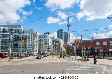 TORONTO, CANADA, 30TH JULY 22: A View Along Queens Quay West Towards Downtown Toronto During The Day. People, Cars, Buildings And The CN Tower Can Be Seen.