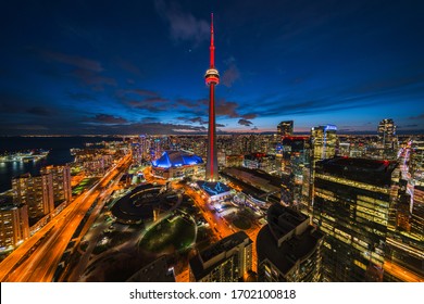 Toronto, Canada - April 10, 2020: Panoramic View Of Toronto Cityscape Including Architectural Landmark CN Tower Illuminated At Night In Toronto, Ontario, Canada. 