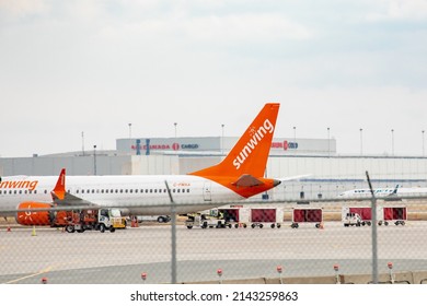 Toronto, Canada, April 4, 2022;  A Sunwing Boeing 737 parked at the terminal at Toronto Pearson Airport, YYZ, seen through a fence