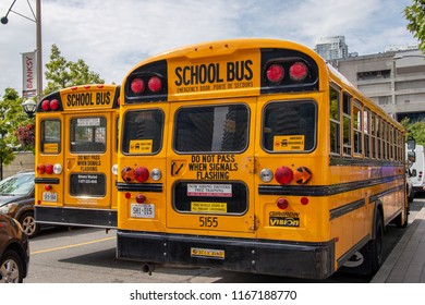 TORONTO, CANADA - AUG 14 2018: Two school buses in traffic in downtown Toronto, Canada.