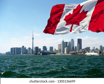  TORONTO, CANADA - Canadian Flag Is Waving Front Of Toronto City View