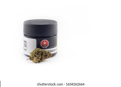 Toronto, Canada - Feb 02 2020: Closeup macro of dried cannabis marijuana weed buds and package of legal cannabis for medical recreational purpose on white background. Space for copy. Selective focus.