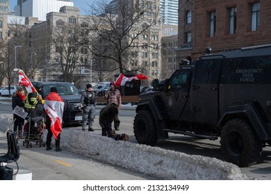 Toronto Canada Feb 13 2022: People Walking By Emergency Task Force Truck During Peaceful Protest Against Covid 19 Mandates And Restrictions And Mandatory Vaccination In Toronto City Downtown.