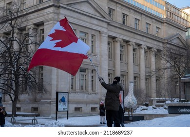 Toronto Canada Feb 5 2022: Man Waving Large Canadian Flag At Peaceful Protest Against Covid 19 Mandates And Restrictions And Mandatory Vaccination In Toronto City Downtown.