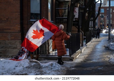 Toronto Canada Feb 5 2022: Woman Holding Canadian Flag At Peaceful Protest Against Covid 19 Mandates And Restrictions And Mandatory Vaccination In Toronto City Downtown.