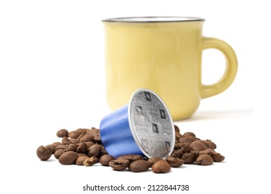 Toronto Canada, February 13m 2022; A Nespresso brand espresso coffee pod surrounded by coffee beans with an espresso cup in the background isolated on white