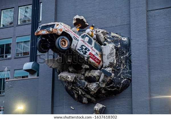 Toronto, Canada - Jul 3, 2019: CP24 Breaking News\
3D signature van crashing through building wall sign, with spinning\
wheels (Queen Street\
West)