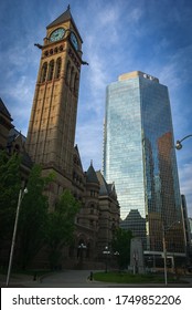 TORONTO, CANADA - JUNE 04, 2020: Toronto Old City Hall Clock Tower And Cadillac Fairview Skyscraper Building From Bellow At Sunset