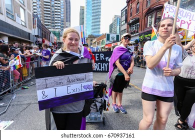 TORONTO, CANADA - JUNE 25, 2017: ASEXUALS march, holding I AM ASEXUAL AND I EXIST sign, at 2017 Toronto Pride Parade.