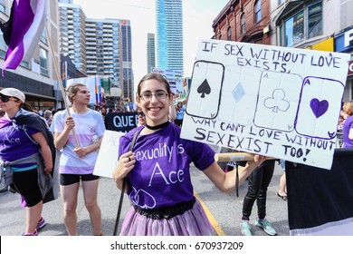 TORONTO, CANADA - JUNE 25, 2017: ASEXUALS march, holding IF SEX EXISTS WITHOUT LOVE, WHY CAN'T LOVE EXIST WITHOUT SEX sign, at 2017 Toronto Pride Parade. 