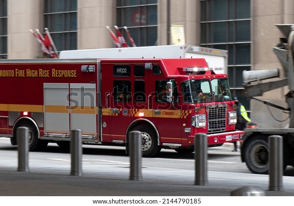 Toronto, Canada - March 28, 2022: A Toronto Fire\
truck is seen responding to a call, rushing through the busy street\
in downtown Toronto.