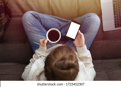 Toronto, Canada - May, 2,2020: Top View Of Woman Sitting On Sofa Using Mock Up Phone And Coffee On Her Lap, Online Business Or Communication Concept