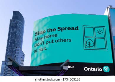 TORONTO, CANADA - May 7, 2020: “Stop The Spread. Stay Home. Don’t Put Others At Risk.” COVID-19 Coronavirus Information Sign In Young-Dundas Square Toronto Promoted By The Government Of Ontario.