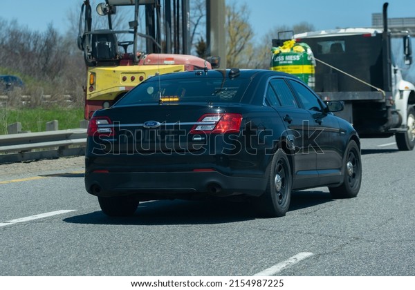 Toronto Canada May 7 2022: Close view of OPP\
unmarked undercover police cruiser interceptor following a car on\
the highway. Dangerous, careless driving, speeding, DUI, traffic\
violations concept.