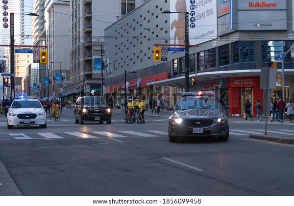 Toronto, Canada - Nov 14, 2020: Urban scene -\
multiple police cruiser vehicles and many bicycle cops on the\
street in downtown Toronto during anti covid 19 pandemic lockdown\
quarantine protest\
march.
