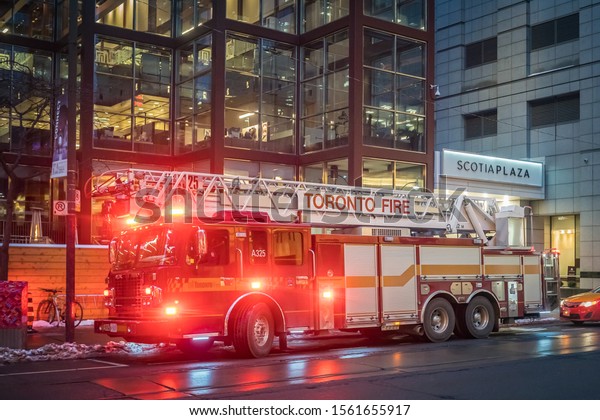 TORONTO,\
CANADA - NOVEMBER 14, 2019: Toronto Fire Department truck with\
siren and lights turned on near Scotia\
Plaza